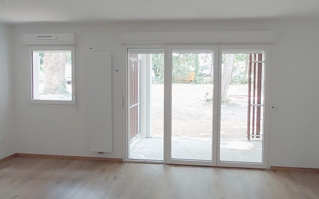 Porte fenêtre PVC blanc à 2 vantaux + fixe latéral avec volet roulant. Fenêtre 1 vantail avec volet roulant.